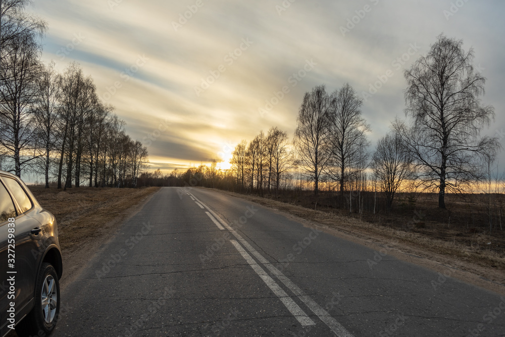 Fototapeta premium Suburban road goes into the distance at sunset