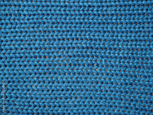 Blue knitted textured background, knit with facial loops.