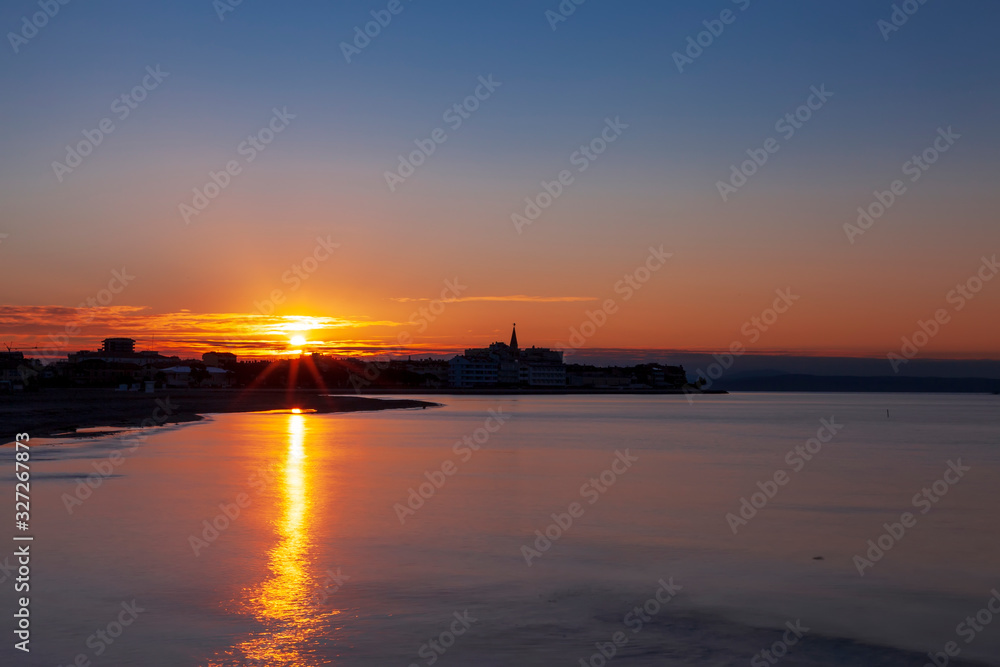 Alba sulla città di Grado, provincia di Gorizia, in Italia, vista dalla laguna.