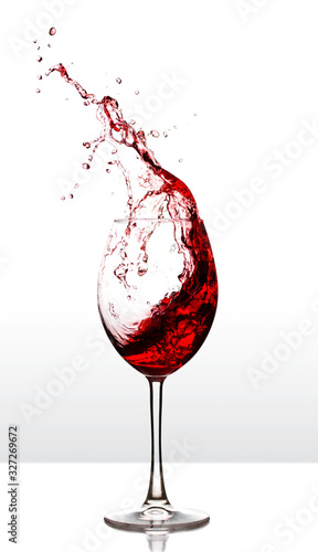 Red wine splash on table over white background.