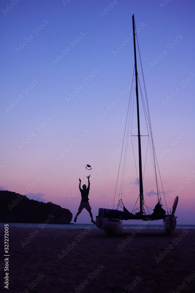 Φωτογραφία Men enjoying photography with camera near a sailboat on the beach in the evening
