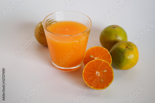 Orange juice in glass and orange fruit on white background, Zoom macro.