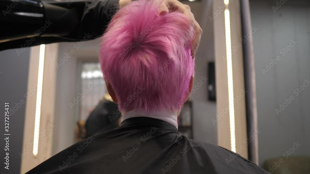Short pink hair is blow-dried in a hair salon.Rear view from below. Slow motion Short pink hair is blow-dried in a hair salon.Rear view from below. Slow motion