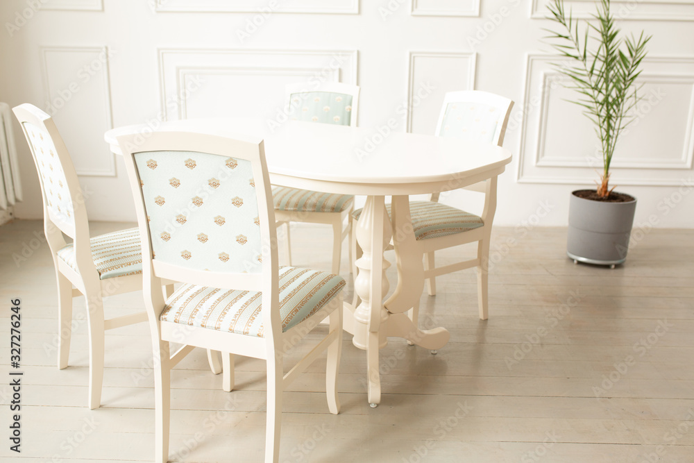 White tables and chairs for dinner in a classic interior. White tables and chairs for dinner in a classic interior.