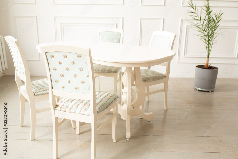 White tables and chairs for dinner in a classic interior.