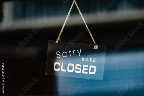 Fototapeta sorry we are closed sign hanging outside a restaurant, store, office or other