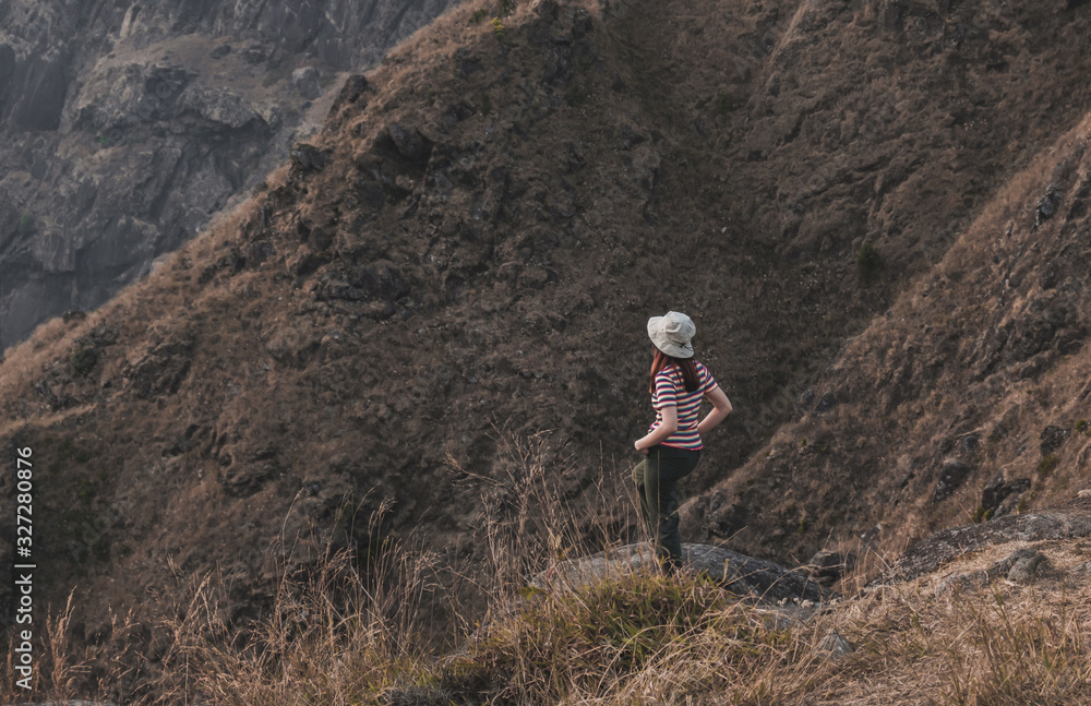 Naklejka premium Cute girl with a hiking traveler. red white Stripes stand back on the big stone mountain view and dig a trouser. At Mulayit Taung in Myanmar.
