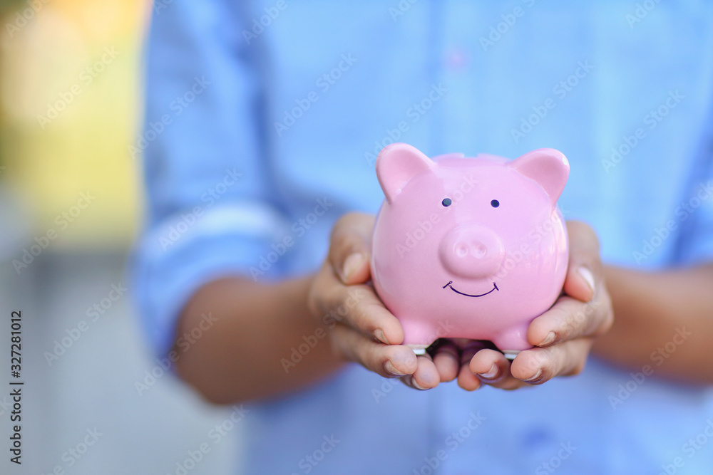 Indian little boy holding the piggy bank for his savings Indian little boy holding the piggy bank for his savings