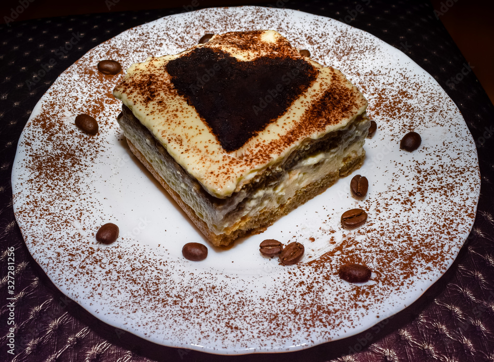 Nicely plated tiramisu cake with sprinkled cocoa and coffee beans Nicely plated tiramisu cake with sprinkled cocoa and coffee beans