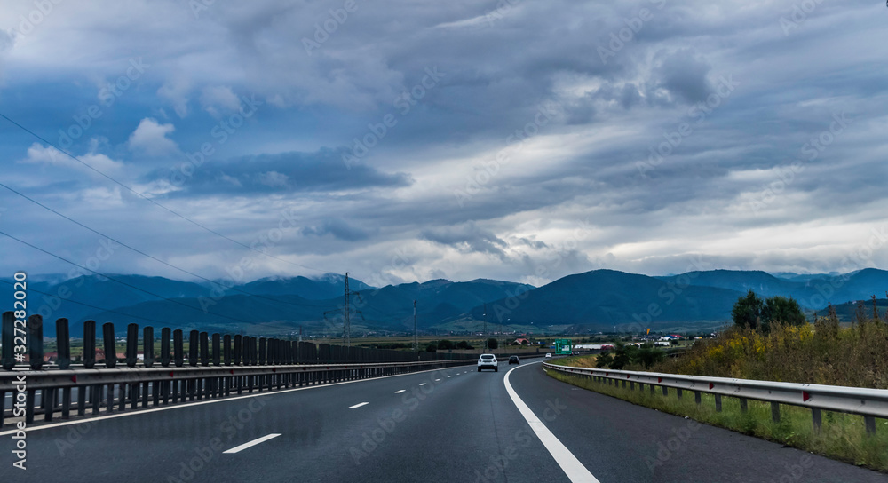 Highway with mountains in the background on an overcast day