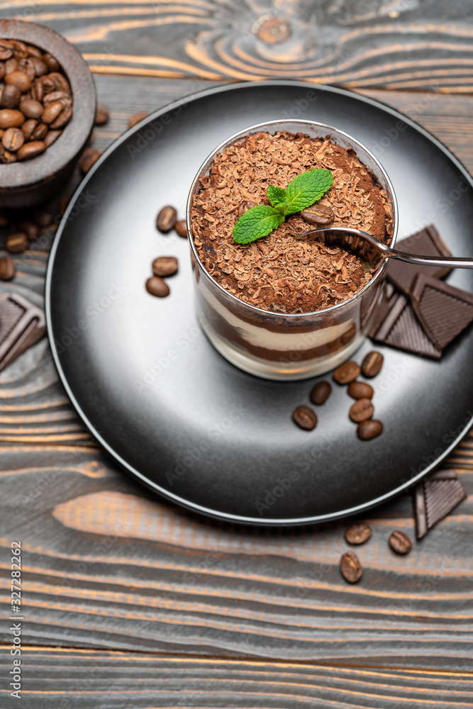 Classic tiramisu dessert in a glass cup on wooden background Classic tiramisu dessert in a glass cup on wooden background