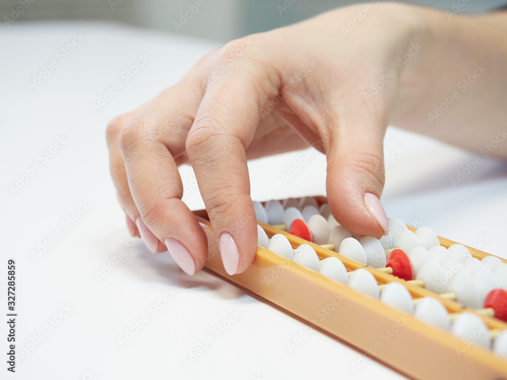 Classes in mental arithmetic, hands and abacus soroban on white background. closeup. copy space Classes in mental arithmetic, hands and abacus soroban on white background. closeup. copy space