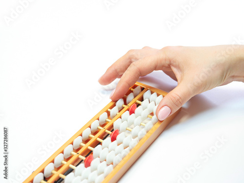 Classes in mental arithmetic  hands and abacus soroban on white background. closeup. copy space