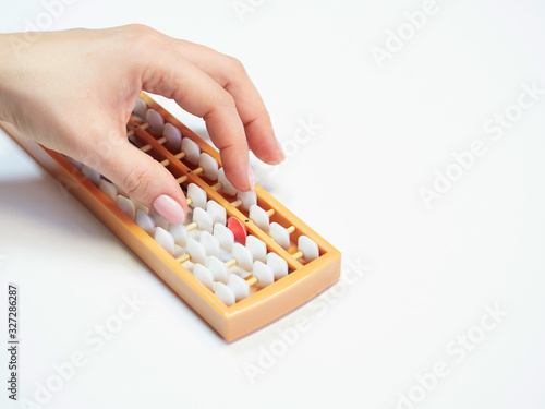 Classes in mental arithmetic  hands and abacus soroban on white background. closeup. copy space