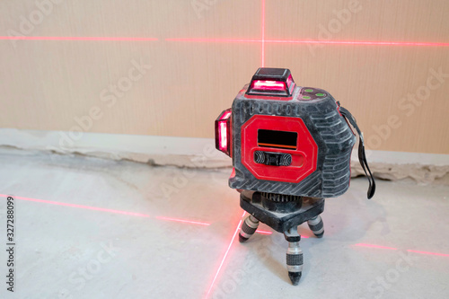 Construction laser level on a wall background. Apartment renovation, construction work.