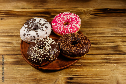 Tasty donuts on plate on a wooden table