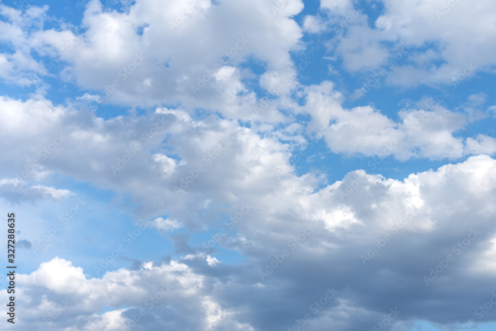 Naklejka premium White cumulus clouds against the background against blue on a blue background.