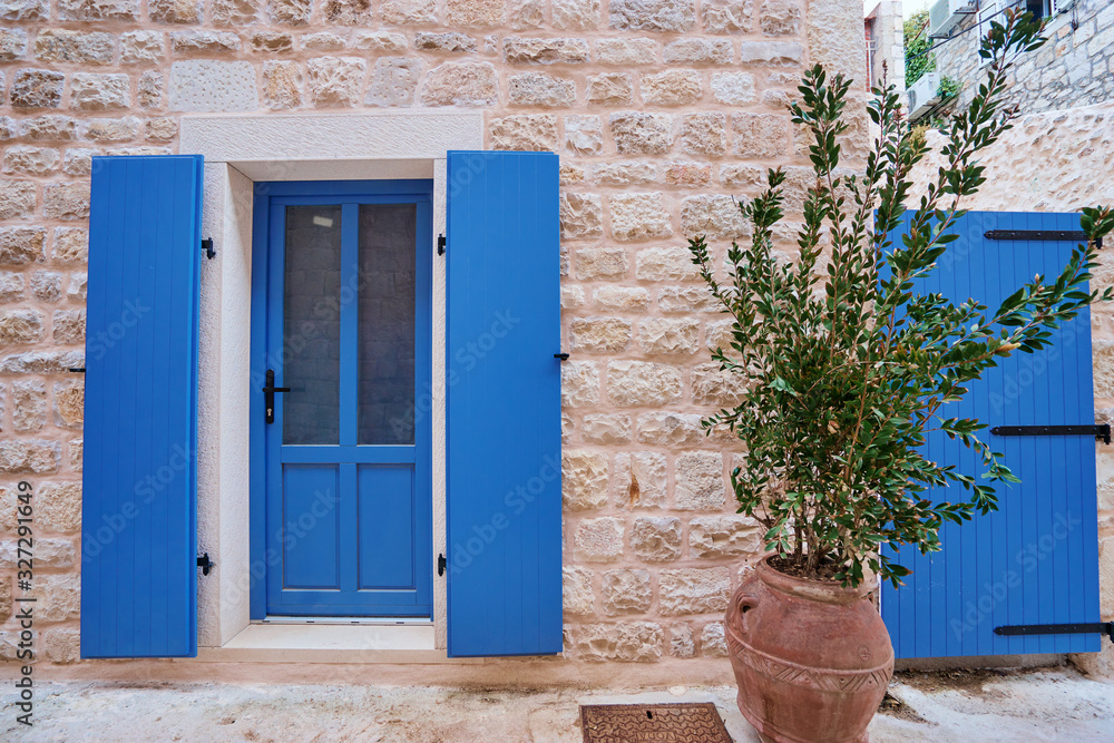 Fototapeta premium White old building with blue wooden vintage door.