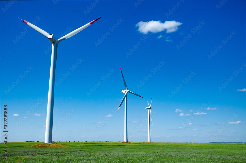Fototapeta premium Wind turbines on green field blue sky clouds green energy concept renewable energy generator