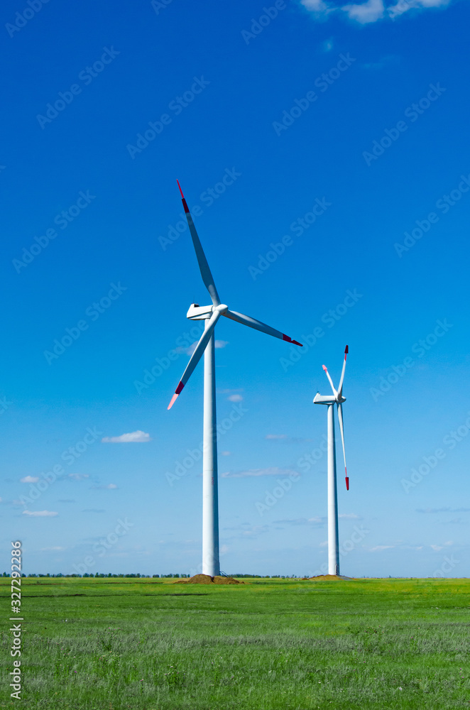 Wind turbines on green field blue sky clouds green energy concept renewable energy generator Wind turbines on green field blue sky clouds green energy concept renewable energy generator