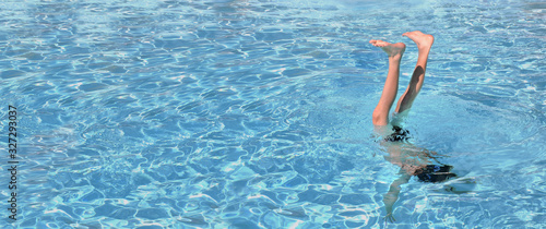 legs of a young man enjoying in a pool with his legs outside the water