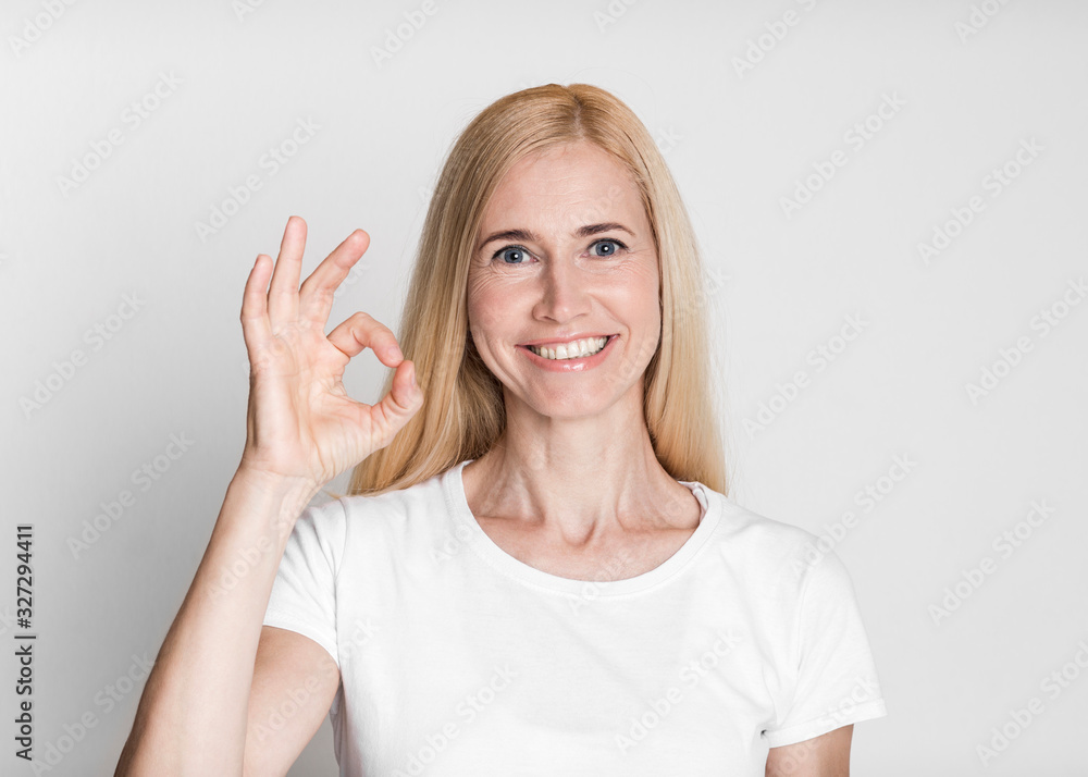 Happy mature woman gesturing ok sign and smiling Happy mature woman gesturing ok sign and smiling
