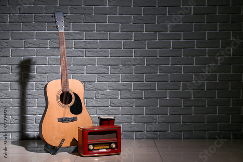 Fototapeta Modern guitar, drum and radio receiver near brick wall