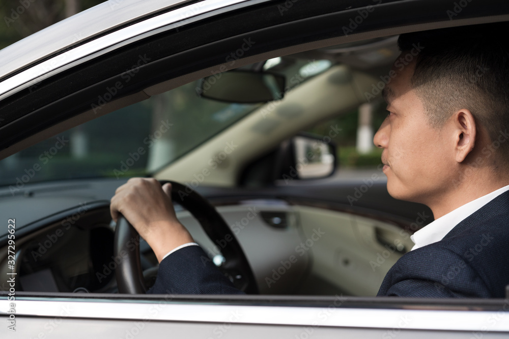 Asian men in front of the office building work in cars Asian men in front of the office building work in cars