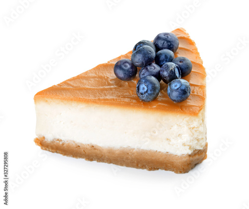 Slice of sweet caramel cheesecake with berries on white background