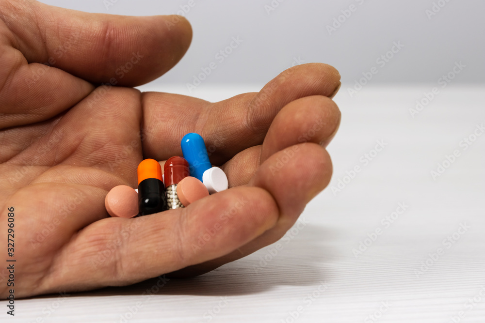 The man is holding a lot of colorful medicine capsules The man is holding a lot of colorful medicine capsules