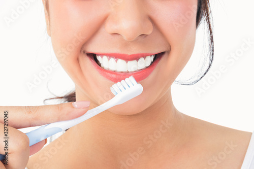 Beautiful smiling woman, clean white teeth, pink lips, hold a toothbrush. Oral care concept. White background