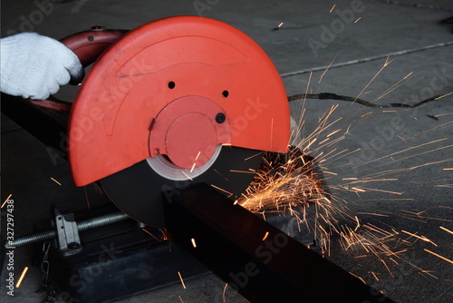  Man uses a metal cutting tool to create a red spark.