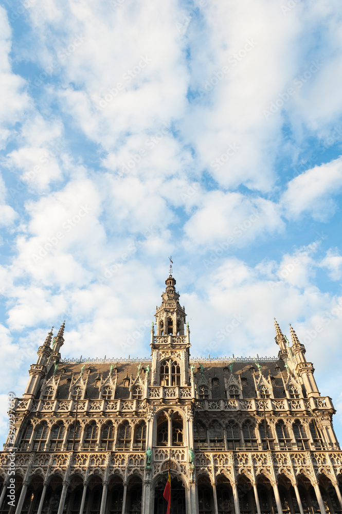 Exterior view of the Gothic Revival architecture of the King's House building (1873) in the Grand Place, Brussels, Belgium under sunny blue sky
