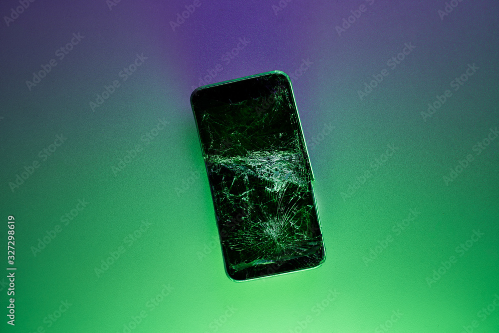 Mobile smartphone with broken screen on green background. Mobile smartphone with broken screen on green background.