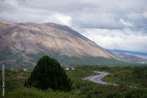 S-curve road near hill with Green tree and sky in Iceland