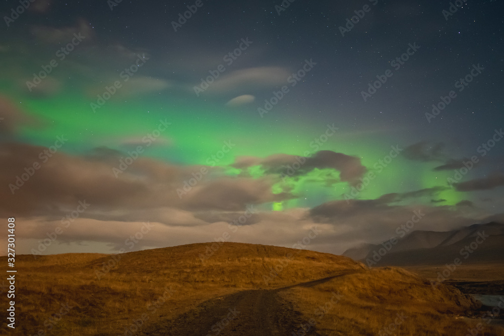 Aurora Borealis in Iceland northern lights bright beams over hiking path