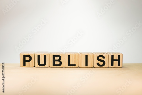 Word PUBLISH on wooden cubes on white background