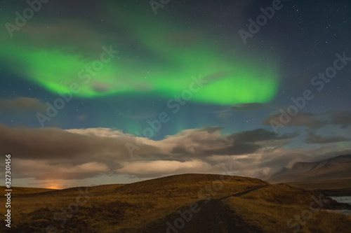Aurora Borealis in Iceland northern lights bright beams rising in green beams over icelandic landscape