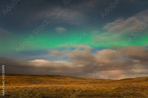 Aurora Borealis in Iceland northern lights shining green in night sky beyond the asterisk Big Dipper