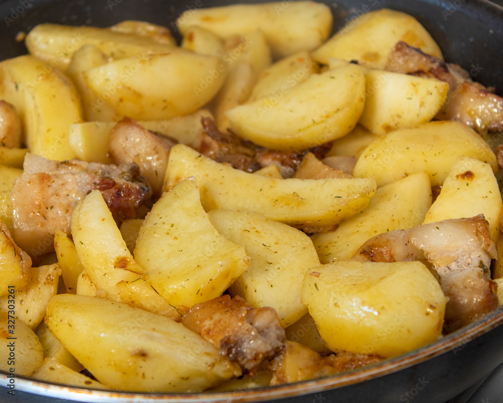 Fried potatoes with meat in a pan with spices cooked at home Fried potatoes with meat in a pan with spices cooked at home