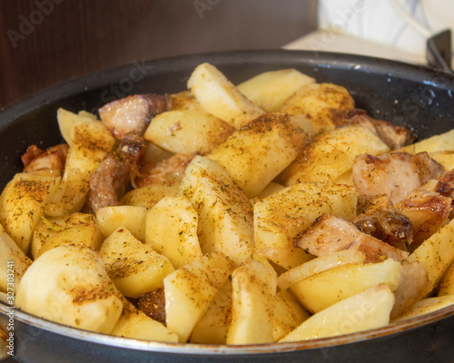 Fried potatoes with meat in a pan with spices cooked at home