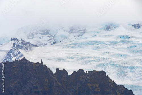 Vatnajoekull glacier in Iceland deep blue ice covering the high top of mountain photo