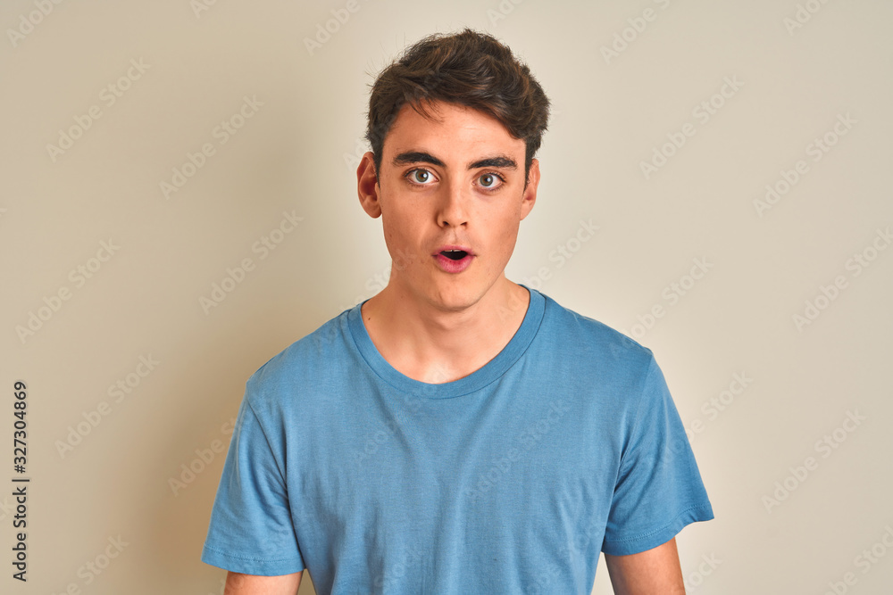 Teenager boy wearing casual t-shirt standing over isolated background afraid and shocked with surprise expression, fear and excited face. Teenager boy wearing casual t-shirt standing over isolated background afraid and shocked with surprise expression, fear and excited face.