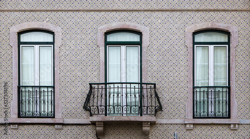 Element of the facade of the house. Old building with a brown wall is decorated with Azulejo, Lisbon, Portugal.