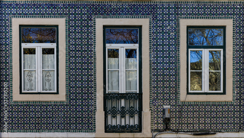 Element of the facade of the house. Old building with a blue wall is decorated with Azulejo, Lisbon, Portugal.
