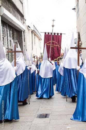 Christian Holy Week procession with Nazarenes and their hoods through the streets of the town © tetxu