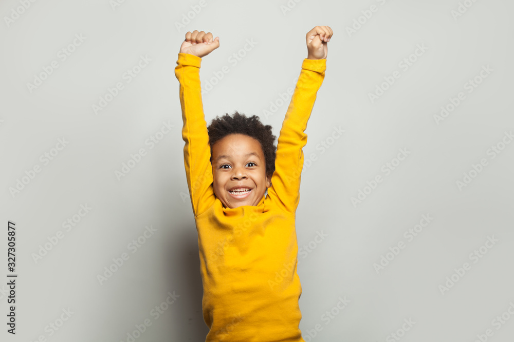 Little black child win-win! Kid boy having fun on white background - obrazy, fototapety, plakaty 