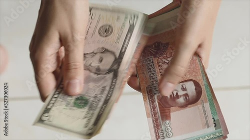 Woman traveler's hands recounts her cash money in different currencies