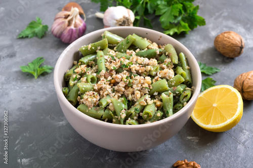 Salad with green beans and spicy walnut sauce in a bowl. Vegetarian, vegan menu.