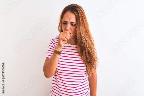 Young redhead woman wearing striped casual t-shirt stading over white isolated background feeling unwell and coughing as symptom for cold or bronchitis. Healthcare concept.